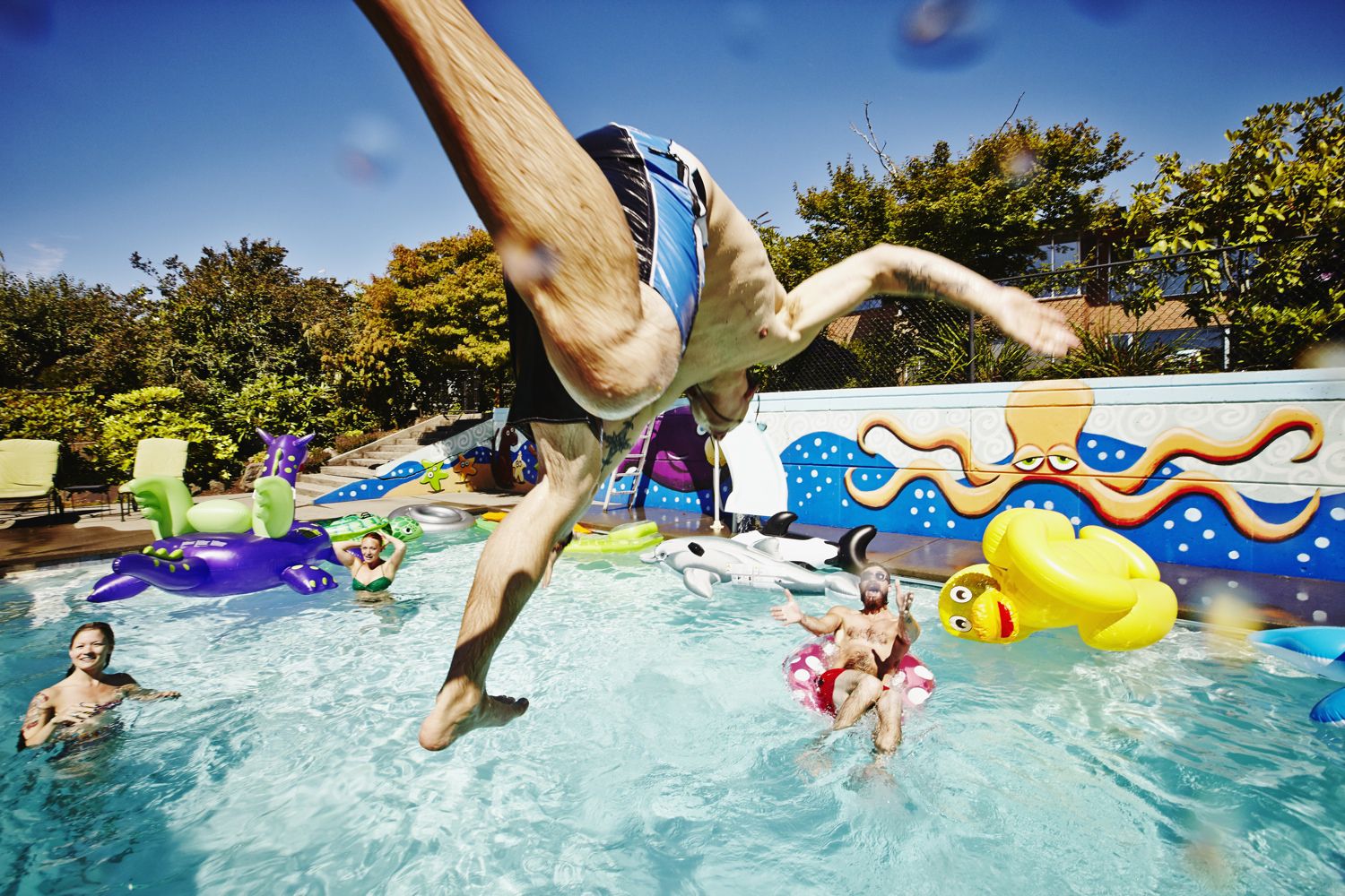 man jumping in the diving board with friends